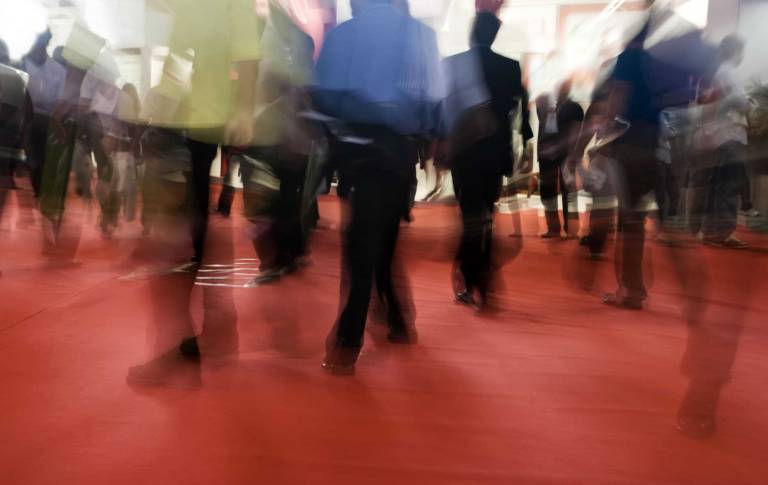 blurred crowd walking across a busy tradeshow floor, representing rising business travel costs, event fatigue, and changing B2B marketing dynamic