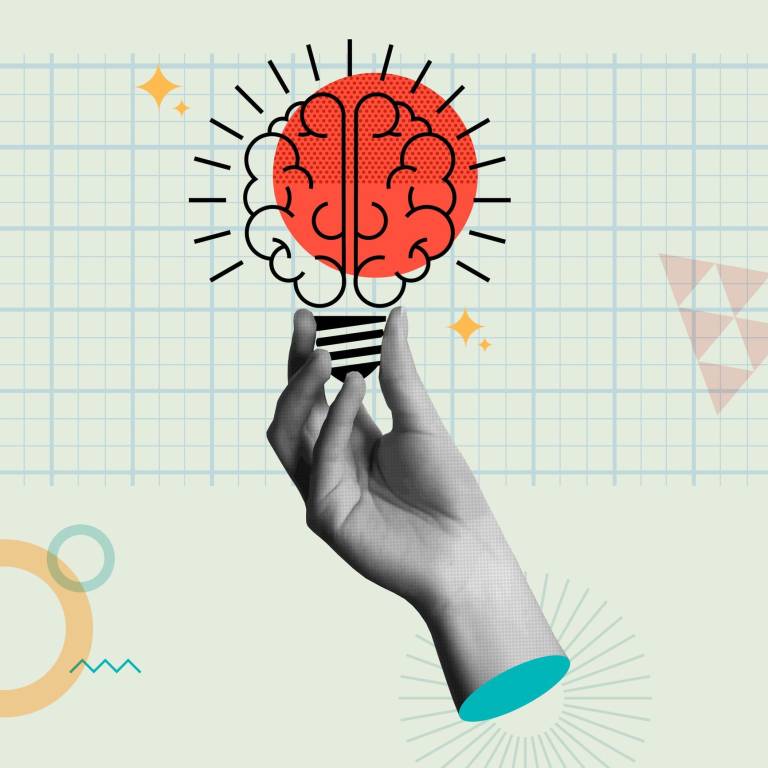 Fingers holding lightbulb with brain illustrating aha moment