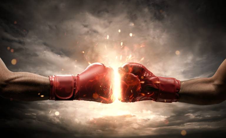 Two red boxing gloves coming from left and right fist bumping in the center and creating a kind of explosion with light spilling out and clouds in the background
