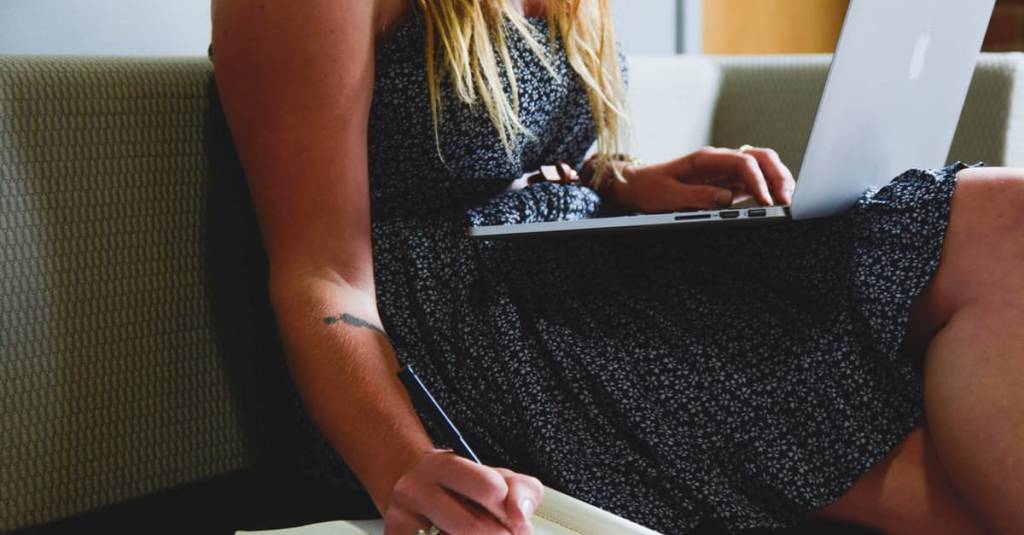 Picture of a woman writing notes while working on headlining.