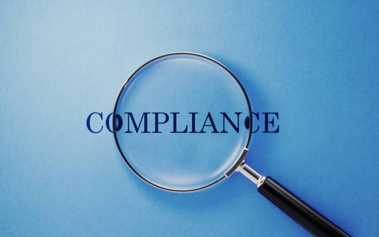 Magnifier and compliance text on blue background