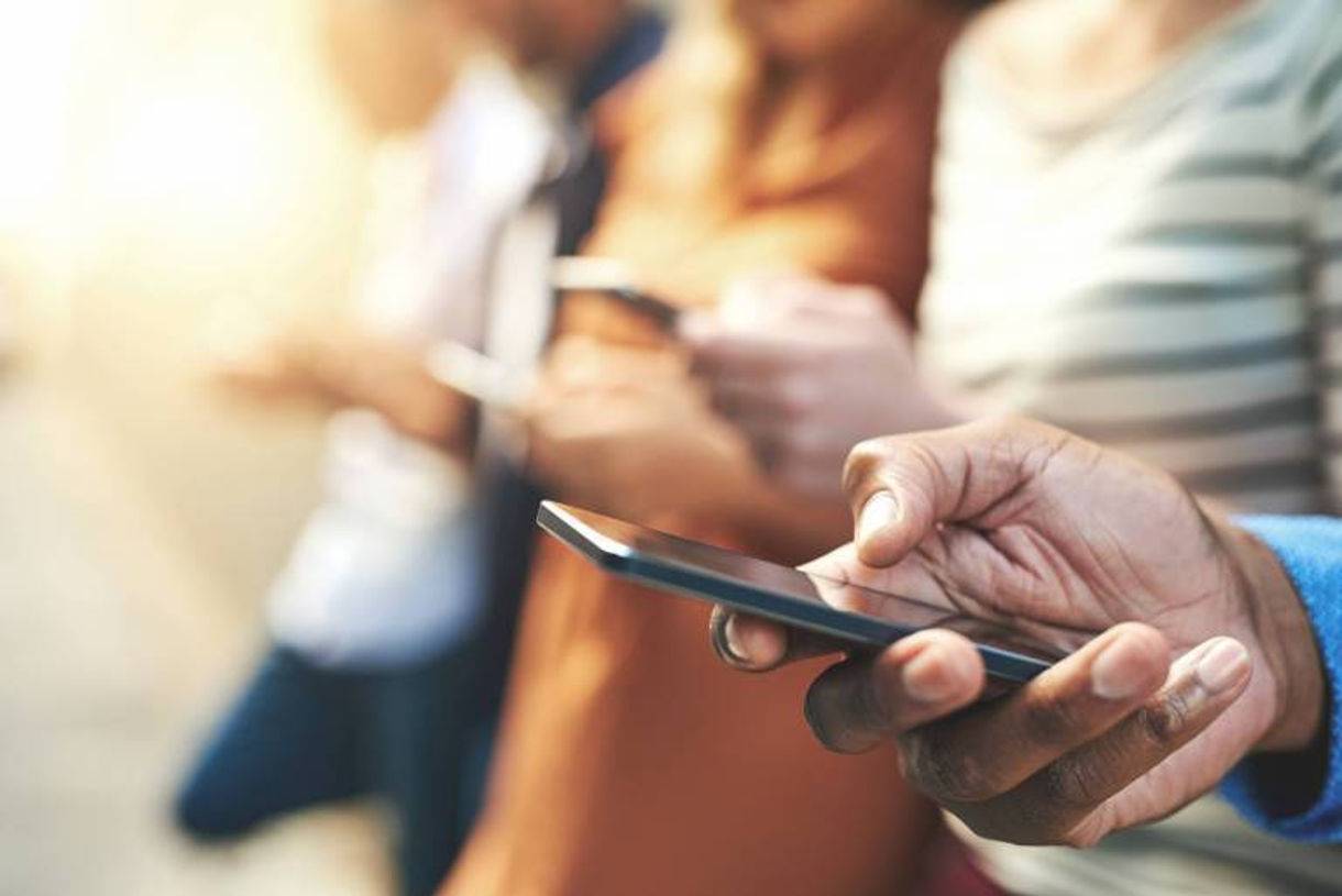 group of people holding and looking at their mobile device smartphones