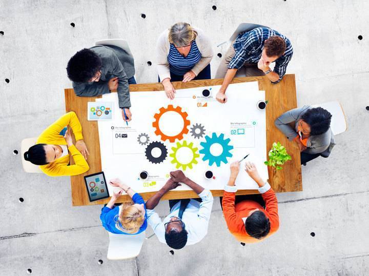 Picture showing people seated at a planning table demonstrating teamwork.